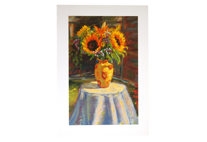Reproduksjon med motiv av solsikker i gul vase på bord med hvit duk. Bilde.